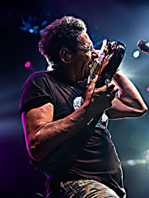 icardo Mollo en un concierto, tocando la guitarra con energía y pasión.